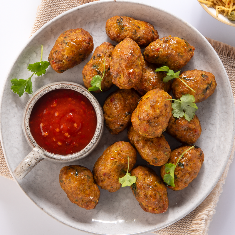 Bowl of chicken sheesh bites with a side of red sauce